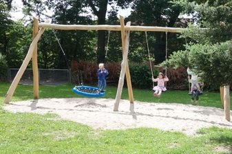 Kinder schaukeln im Hof