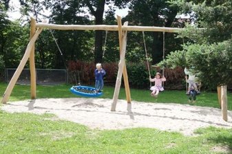 Kinder schaukeln im Hof